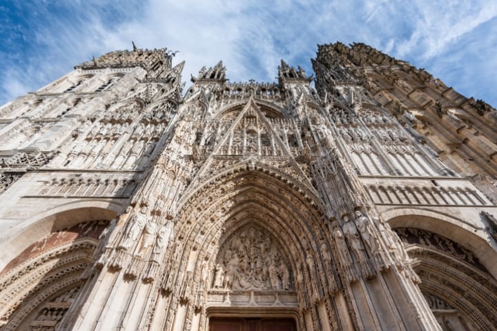 The sculpted western facade of the Gothic-style Rouen Cathedral.