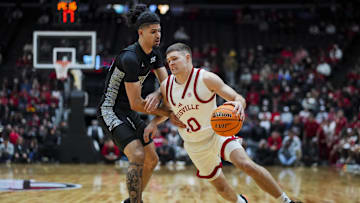 Nov 21, 2025; Cincinnati, Ohio, USA; Cincinnati Bearcats guard Shon Abaev (10) defends against Louisville Cardinals guard Isaac McKneely (10) in the first half at Heritage Bank Center. Mandatory Credit: Aaron Doster-Imagn Images