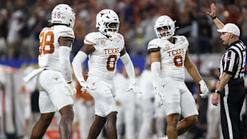Jan 10, 2025; Arlington, Texas, USA; Texas Longhorns linebacker Anthony Hill Jr. (0) celebrates with linebacker Barryn Sorrell (88) and linebacker Trey Moore (8) after a play during the second quarter of the College Football Playoff semifinal against the Ohio State Buckeyes in the Cotton Bowl at AT&T Stadium. Mandatory Credit: Tim Heitman-Imagn Images