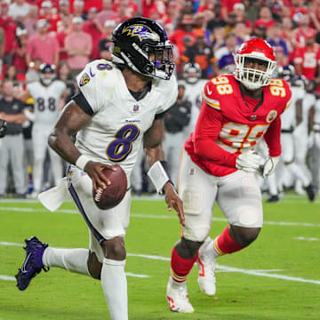 Baltimore Ravens quarterback Lamar Jackson (8) runs the ball as Kansas City Chiefs defensive tackle Tershawn Wharton (98) chases during the second half at GEHA Field at Arrowhead Stadium. 