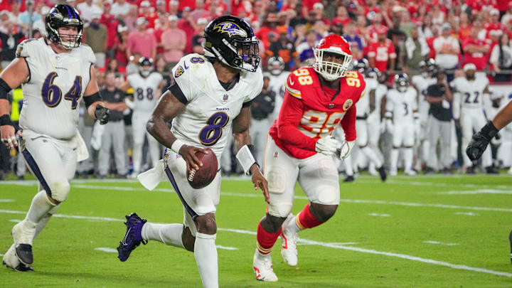 Baltimore Ravens quarterback Lamar Jackson (8) runs the ball as Kansas City Chiefs defensive tackle Tershawn Wharton (98) chases during the second half at GEHA Field at Arrowhead Stadium. 