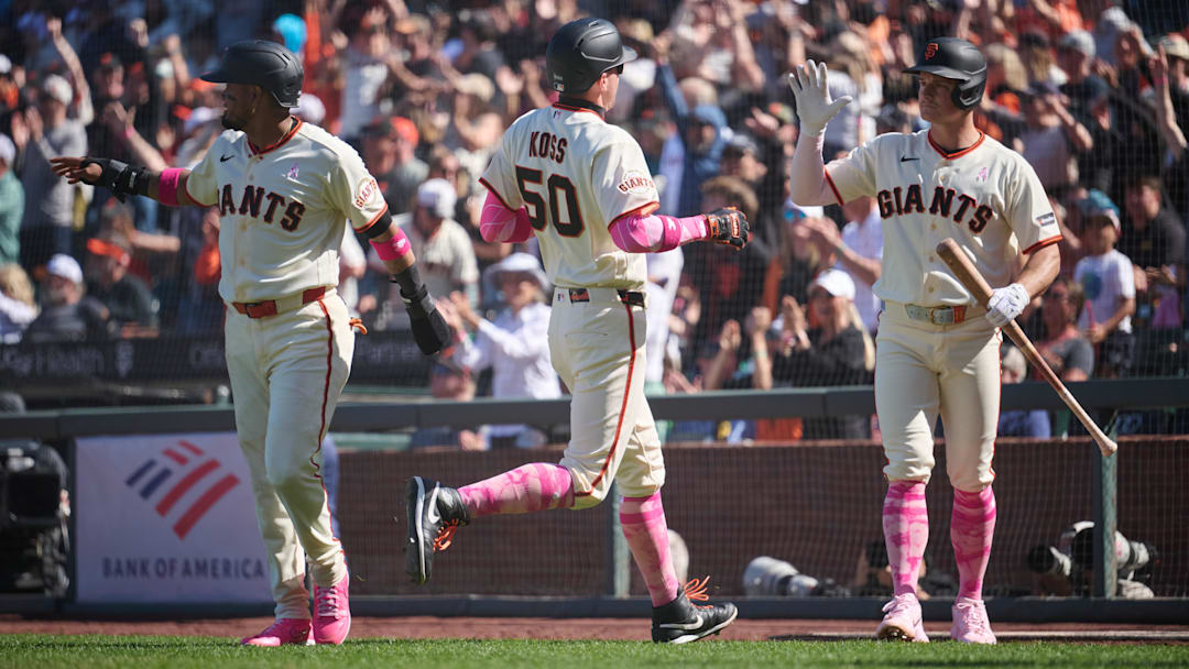 May 10, 2026; San Francisco, California, USA; San Francisco Giants infielder Christian Koss (50) celebrates with infielders Matt Chapman (26) and Luis Arraez (1) after scoring a run against the Pittsburgh Pirates during the tenth inning at Oracle Park. Mandatory Credit: Robert Edwards-Imagn Images