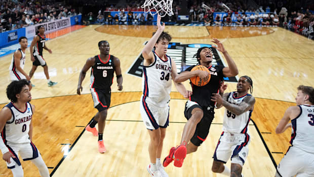 Georgia guard Tyrin Lawrence (7) drives against Gonzaga Bulldogs forward Braden Huff (34) and guard Khalif Battle (99).