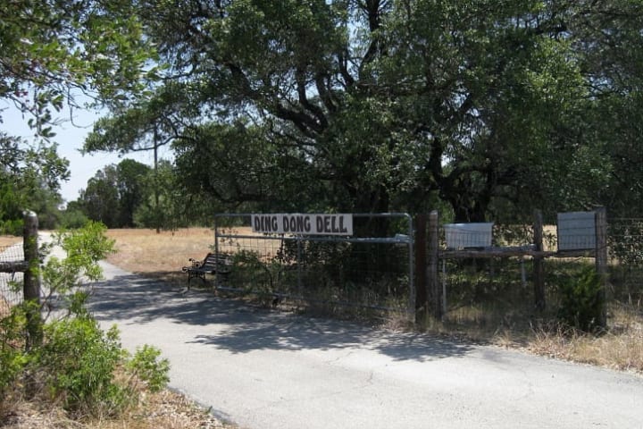 A sign on a gate in Ding Dong, Texas.