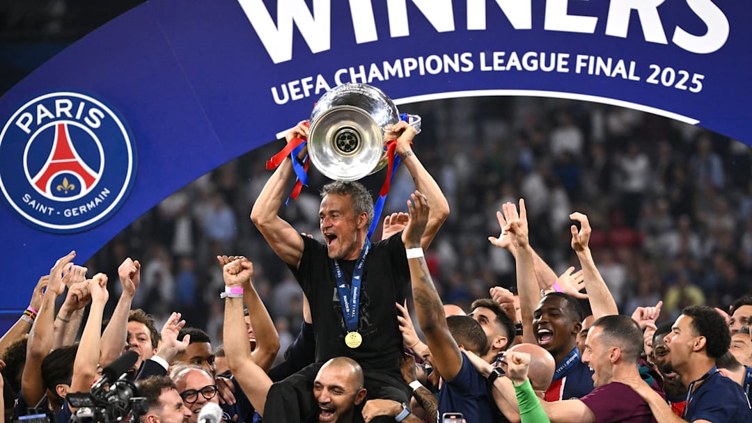 PSG's players hoist Luis Enrique while he hoists the European Cup for the first time.
