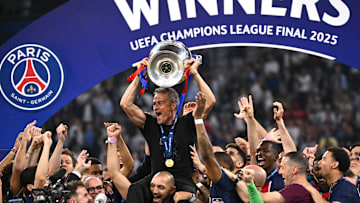 PSG's players hoist Luis Enrique while he hoists the European Cup for the first time.
