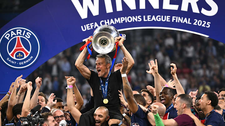 PSG's players hoist Luis Enrique while he hoists the European Cup for the first time.