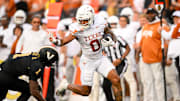 Oct 26, 2024; Nashville, Tennessee, USA; Texas Longhorns wide receiver DeAndre Moore Jr. (0) stiff arms Vanderbilt Commodores safety CJ Taylor (1) as he crosses the goal line  during the first half at FirstBank Stadium. Mandatory Credit: Steve Roberts-Imagn Images