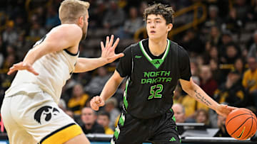 Nov 7, 2023; Iowa City, Iowa, USA; North Dakota Fighting Hawks guard Treysen Eaglestaff (52) dribbles against Iowa Hawkeyes forward Ben Krikke (23) during the first half at Carver-Hawkeye Arena. Mandatory Credit: Jeffrey Becker-Imagn Images