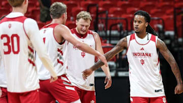 Indiana basketball guard Lamar Wilkerson high-fives teammate Trent Sisley, standing between Tucker DeVries and Ian Stephens.