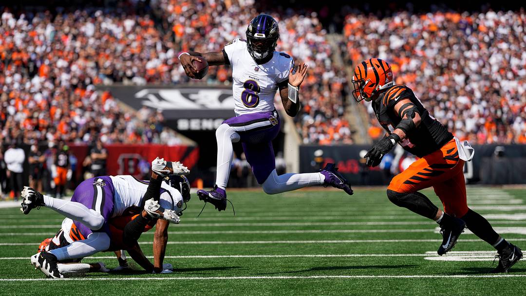 Baltimore Ravens quarterback Lamar Jackson (8) leaps away from Cincinnati Bengals defensive end Sam Hubbard (94) on a keeper in the first quarter of the NFL Week 5 game between the Cincinnati Bengals and Baltimore Ravens at Paycor Stadium in downtown Cincinnati on Sunday, Oct. 6, 2024. The Bengals led 17-14 at halftime.