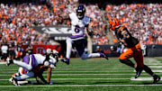 Baltimore Ravens quarterback Lamar Jackson leaps away from Cincinnati Bengals defensive end Sam Hubbard.
