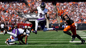 Baltimore Ravens quarterback Lamar Jackson (8) leaps away from Cincinnati Bengals defensive end Sam Hubbard (94) on a keeper in the first quarter of the NFL Week 5 game between the Cincinnati Bengals and Baltimore Ravens at Paycor Stadium in downtown Cincinnati on Sunday, Oct. 6, 2024. The Bengals led 17-14 at halftime.