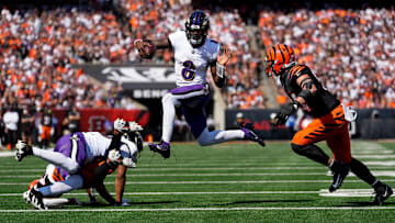 Baltimore Ravens quarterback Lamar Jackson (8) leaps away from Cincinnati Bengals defensive end Sam Hubbard (94) in the first quarter of the NFL Week 5 game between the Cincinnati Bengals and Baltimore Ravens at Paycor Stadium in Cincinnati on Oct. 6, 2024.