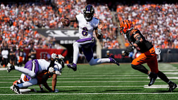 Baltimore Ravens quarterback Lamar Jackson (8) leaps away from Cincinnati Bengals defensive end Sam Hubbard (94) on a keeper in the first quarter of the NFL Week 5 game between the Cincinnati Bengals and Baltimore Ravens at Paycor Stadium in downtown Cincinnati on Sunday, Oct. 6, 2024. The Bengals led 17-14 at halftime.