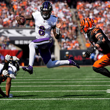 Baltimore Ravens quarterback Lamar Jackson (8) leaps away from Cincinnati Bengals defensive end Sam Hubbard (94) on a keeper in the first quarter of the NFL Week 5 game between the Cincinnati Bengals and Baltimore Ravens at Paycor Stadium in downtown Cincinnati on Sunday, Oct. 6, 2024. The Bengals led 17-14 at halftime.
