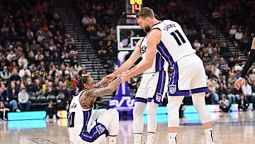 Feb 26, 2025; Salt Lake City, Utah, USA;  Sacramento Kings guard DeMar DeRozan (10) is helped up by teammates guard Zach LaVine (8) and forward Domantas Sabonis (11) in the first half against the Utah Jazz at Delta Center. Mandatory Credit: Jamie Sabau-Imagn Images