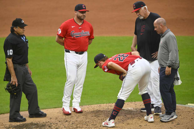 Tanner Bibee (28) stretches beside manager Stephen Vogt (12) and pitching coach Carl Willis (51) before leaving the game.