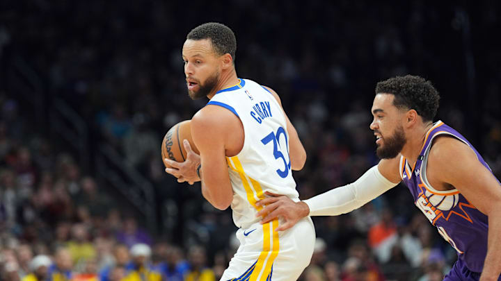 Golden State Warriors guard Stephen Curry (30) dribbles against Phoenix Suns guard Tyus Jones (21) during the first half at Footprint Center. 