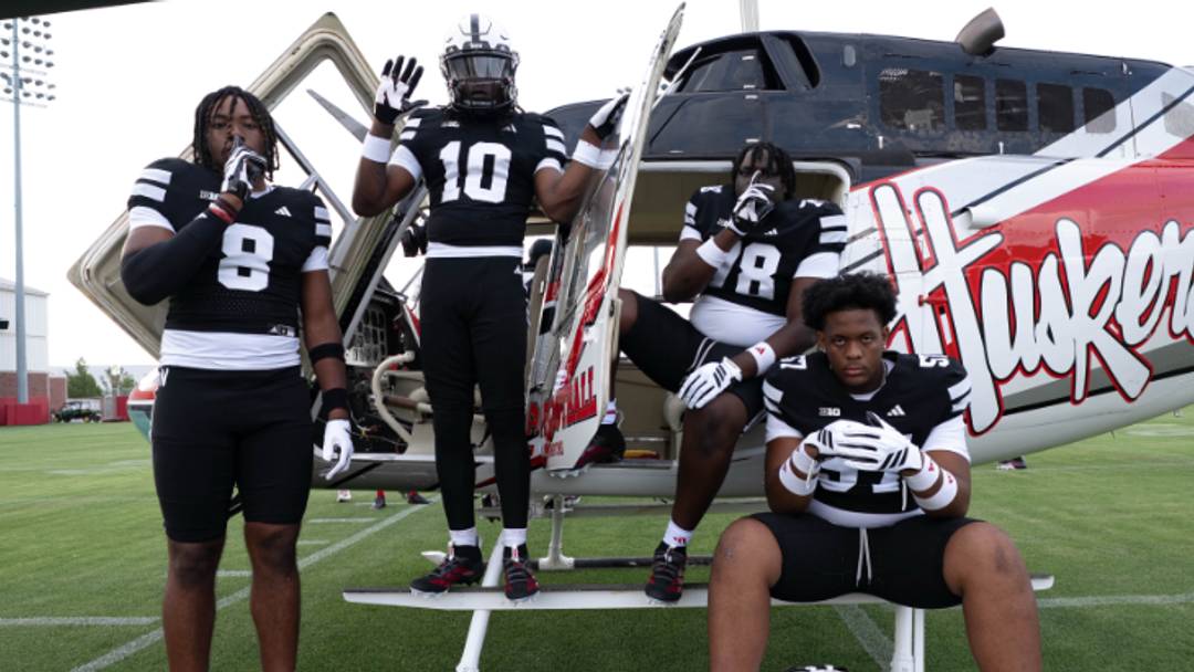 Nebraska football recruits pose with a Huskers-branded helicopter during their official visit.