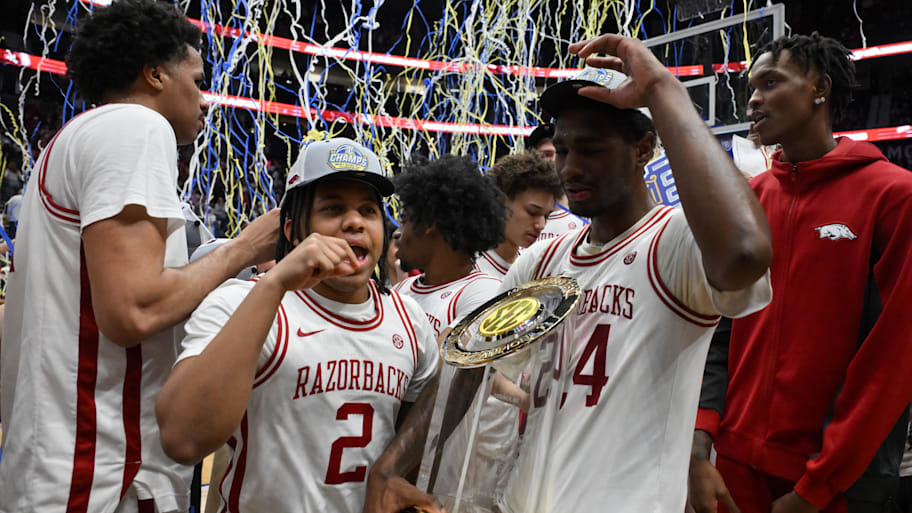 Arkansas Razorbacks guard Amere Brown and forward Billy Richmond III hold the trophy after the men's SEC championship game.