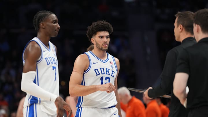 Mar 13, 2026; Charlotte, NC, USA; Duke Blue Devils guard Dame Sarr (7) and forward Cameron Boozer (12) with head coach Jon Scheyer in the first half at Spectrum Center.