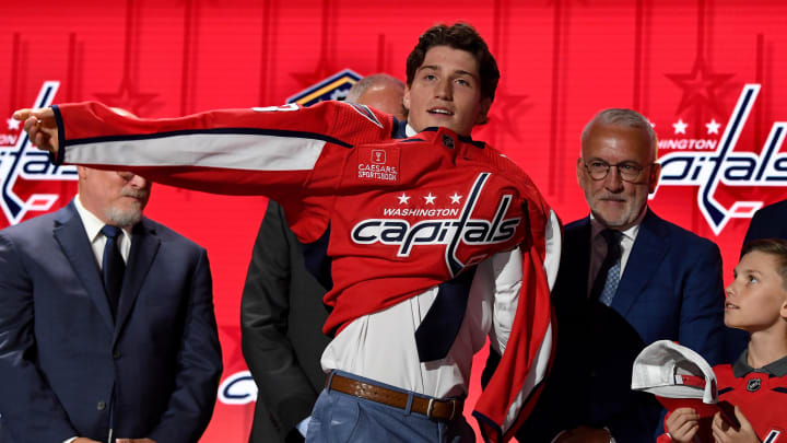 Jun 28, 2023; Nashville, Tennessee, USA; Washington Capitals draft pick Ryan Leonard puts on his sweater after being selected with the eighth pick in round one of the 2023 NHL Draft at Bridgestone Arena. Mandatory Credit: Christopher Hanewinckel-USA TODAY Sports