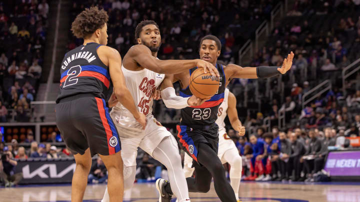 Dec 2, 2023; Detroit, Michigan, USA; Cleveland Cavaliers guard Donovan Mitchell (45) drives the ball up court between Detroit Pistons guard Cade Cunningham (2) and guard Jaden Ivey (23) during the first half at Little Caesars Arena. Mandatory Credit: David Reginek-USA TODAY Sports