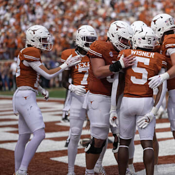 Texas Longhorns celebrate after running back Quintrevion Wisner (5) runs for a touchdown in the first half against the Vanderbilt Commodores at Darrell K Royal-Texas Memorial Stadium.