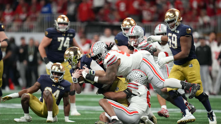 Jan 20, 2025; Atlanta, GA, USA; Notre Dame Fighting Irish quarterback Riley Leonard (13) is sacked by Ohio State Buckeyes safety Sonny Styles (6) and Ohio State Buckeyes defensive tackle Tyleik Williams (91) in the second half in the CFP National Championship college football game at Mercedes-Benz Stadium. Mandatory Credit: Kirby Lee-Imagn Images