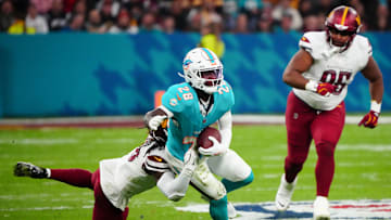 Nov 16, 2025; Madrid, Spain; Miami Dolphins running back De'Von Achane (28) carries the ball defended by Washington Commanders linebacker Jordan Magee (58) in the second quarter during the 2025 NFL Madrid Game at Santiago Bernabeu Stadium. Mandatory Credit: Kirby Lee-Imagn Images