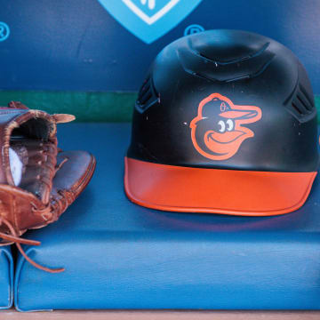Apr 21, 2024; Kansas City, Missouri, USA; Baltimore Orioles hat and glove sits in the dugout during the ninth inning against the Kansas City Royals at Kauffman Stadium.