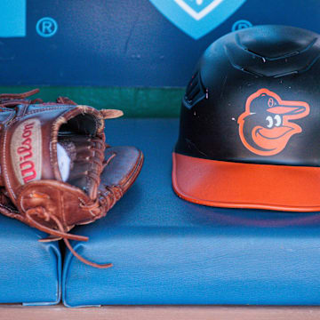 Apr 21, 2024; Kansas City, Missouri, USA; Baltimore Orioles hat and glove sits in the dugout during the ninth inning against the Kansas City Royals at Kauffman Stadium.