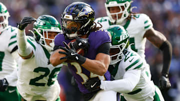 Nov 23, 2025; Baltimore, Maryland, USA;  Baltimore Ravens running back Keaton Mitchell (34) rushes as New York Jets safety Isaiah Oliver (26) and New York Jets safety Tony Adams (22) defend during the second quarter at M&T Bank Stadium. Mandatory Credit: Peter Casey-Imagn Images