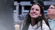 Indiana Fever guard Caitlin Clark smiles while watching the Iowa Hawkeyes and the Michigan State Spartans.