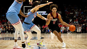 Cincinnati Bearcats guard Dan Skillings Jr. (0) drives on Dayton Flyers guard Koby Brea (4) in the first half of the NCAA men's basketball game between the Dayton Flyers and Cincinnati Bearcats at Heritage Bank Center in Cincinnati on Saturday, Dec. 16, 2023.