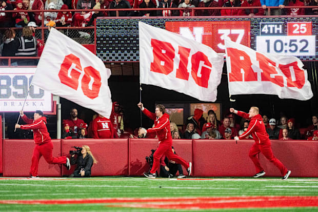 Nebraska Cornhuskers cheerleaders carry flags across the field after a score against the Wisconsin Badgers.
