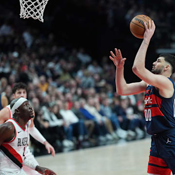 Mar 17, 2025; Portland, Oregon, USA; Washington Wizards power forward Tristan Vukcevic (00) shoots over Portland Trail Blazers center Duop Reath (26) during the first half at Moda Center. Mandatory Credit: Soobum Im-Imagn Images