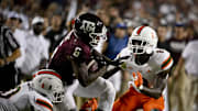 Texas A&M Aggies running back Devon Achane (6) and Miami Hurricanes safety James Williams (0) and cornerback DJ Ivey (8) in action during the game between the Texas A&M Aggies and the Miami Hurricanes at Kyle Field. 