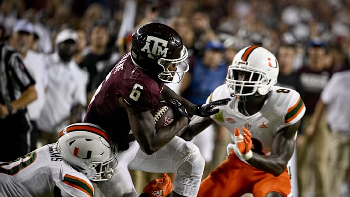 Sep 17, 2022; College Station, Texas, USA; Texas A&M Aggies running back Devon Achane (6) and Miami Hurricanes safety James Williams (0) and cornerback DJ Ivey (8) in action during the game between the Texas A&M Aggies and the Miami Hurricanes at Kyle Field. Mandatory Credit: Jerome Miron-Imagn Images
