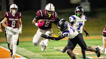 Dowling Catholic’s Ian Middleton (5) looks to break a tackle as he is shoved out of bounds by Waukee’s Jamual Richardson Williams (12) on Oct. 10, 2025, at Valley Stadium in West Des Moines.