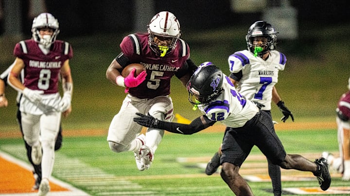 Dowling Catholic’s Ian Middleton (5) looks to break a tackle as he is shoved out of bounds by Waukee’s Jamual Richardson Williams (12) on Oct. 10, 2025, at Valley Stadium in West Des Moines.