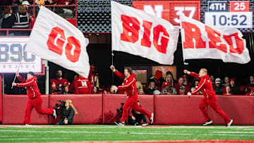 Nebraska Cornhuskers cheerleaders carry flags across the field after a score against the Wisconsin Badgers during the fourth quarter at Memorial Stadium.