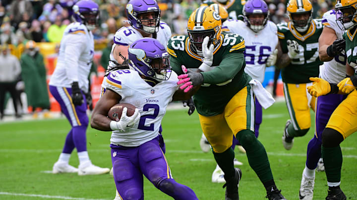 Oct 29, 2023; Green Bay, Wisconsin, USA; Minnesota Vikings running back Alexander Mattison (2) tries to avoid a tackle by Green Bay Packers defensive tackle Tedarrell Slaton (93) in the fourth quarter at Lambeau Field. Mandatory Credit: Benny Sieu-Imagn Images