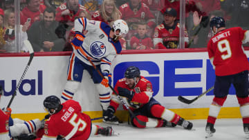 Edmonton Oilers defenseman Brett Kulak (27) fights for the puck
