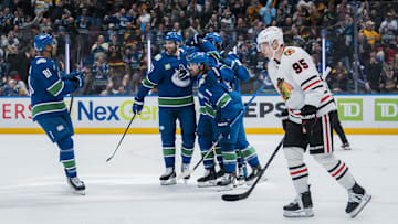 Mar 15, 2025; Vancouver, British Columbia, CAN; Chicago Blackhawks forward Ilya Mikheyev (95) reacts as Vancouver Canucks forward Dakota Joshua (81) and forward Conor Garland (8) and defenseman Derek Forbort (27) and defenseman Vittorio Mancini (90) and forward Pius Suter (24) celebrate Suter’s goal against the Chicago Blackhawks in the third period at Rogers Arena. Mandatory Credit: Bob Frid-Imagn Images