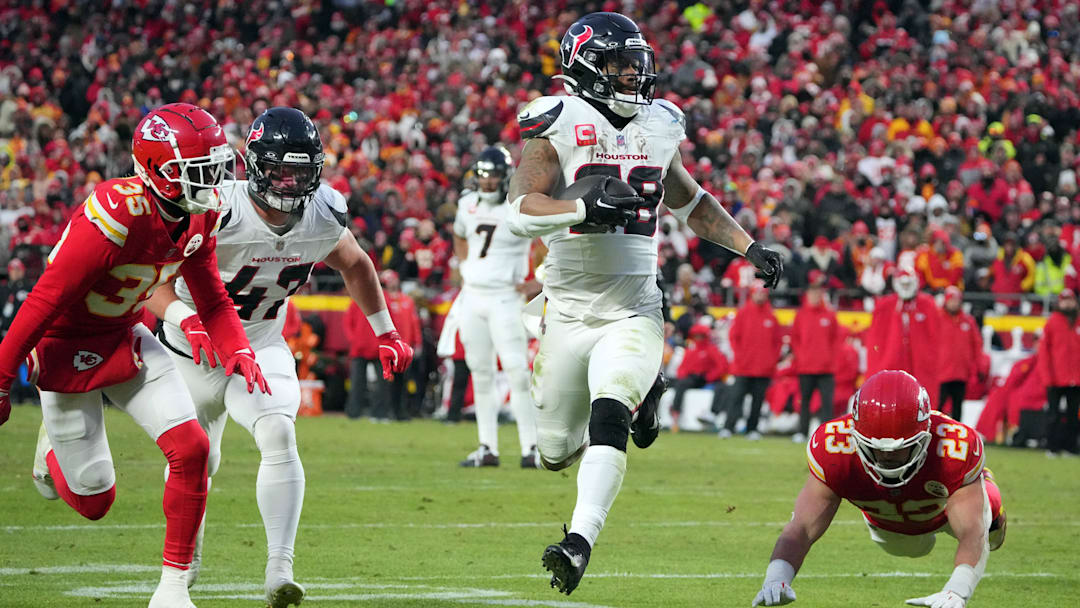 Jan 18, 2025; Kansas City, Missouri, USA; Houston Texans running back Joe Mixon (28) runs the ball in for a touchdown against Kansas City Chiefs cornerback Jaylen Watson (35) and linebacker Drue Tranquill (23) during the third quarter of a 2025 AFC divisional round game at GEHA Field at Arrowhead Stadium. Mandatory Credit: Denny Medley-Imagn Images