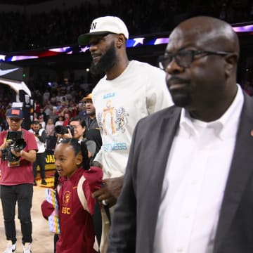 Dec 10, 2023; Los Angeles, California, USA; LeBron James was to his curtsied seats as his son USC Trojans guard Bronny James (6) sands with teammates before the start of a game against the Long Beach State 49ers at Galen Center. Mandatory Credit: Robert Hanashiro-USA TODAY Sports