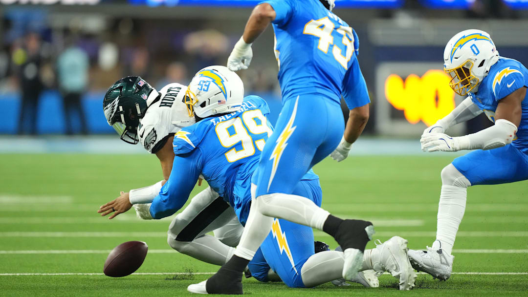 Dec 8, 2025; Inglewood, California, USA; Los Angeles Chargers defensive tackle Jamaree Caldwell (99) tackles Philadelphia Eagles quarterback Jalen Hurts (1) in the first half at SoFi Stadium. Mandatory Credit: Kirby Lee-Imagn Images