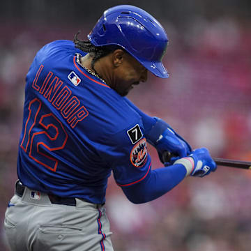 Sep 5, 2025; Cincinnati, Ohio, USA; New York Mets shortstop Francisco Lindor (12) hits a double against the Cincinnati Reds in the fourth inning at Great American Ball Park. Mandatory Credit: Aaron Doster-Imagn Images